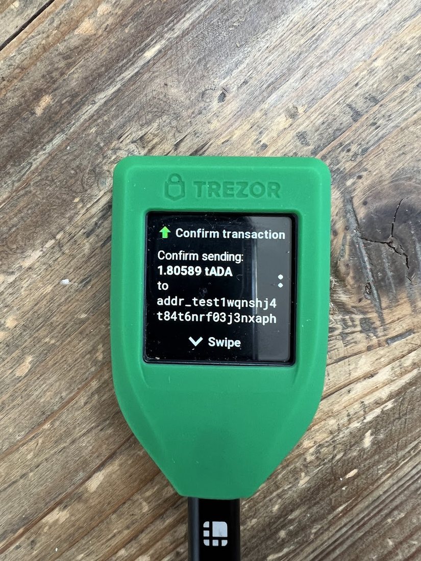 Trezor Model T у захисному чохлі показує екран підтвердження транзакції з адресою отримувача